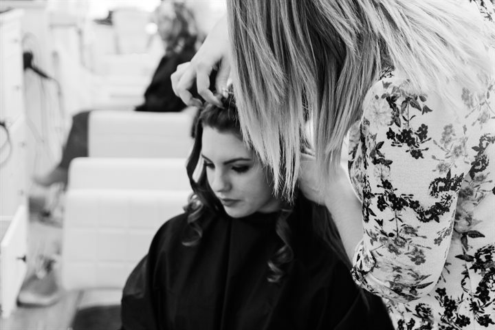 Hairdresser cutting a woman's fringe